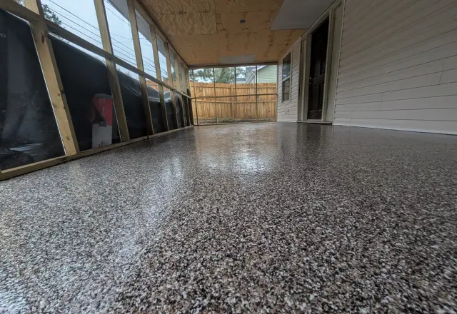 Dark flake floor on a screened back porch with a pine ceiling